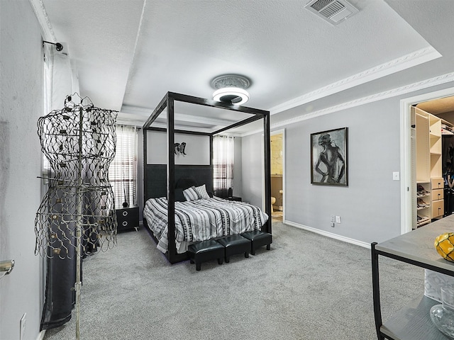 bedroom featuring carpet floors, a textured ceiling, baseboards, and ensuite bathroom