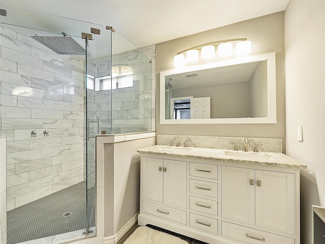 full bath featuring tiled shower and double vanity