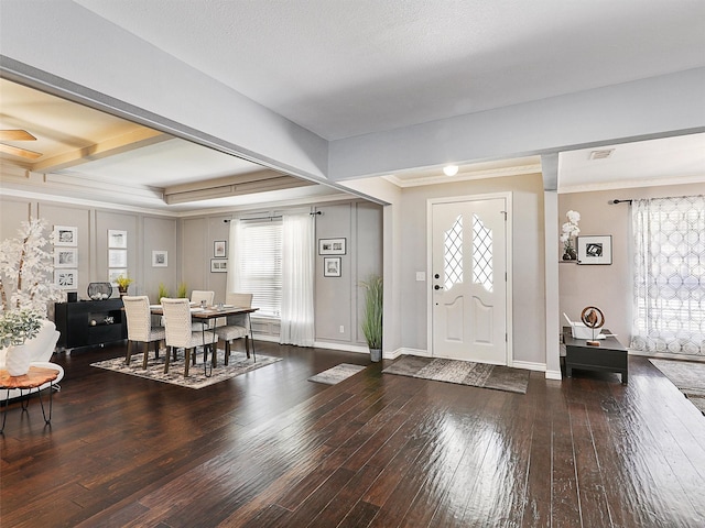 foyer with hardwood / wood-style flooring, plenty of natural light, ornamental molding, baseboards, and beam ceiling