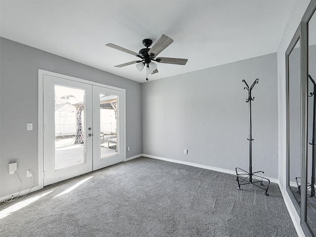 carpeted spare room with french doors, ceiling fan, and baseboards