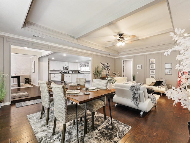 dining space with crown molding, dark wood-style floors, and a ceiling fan