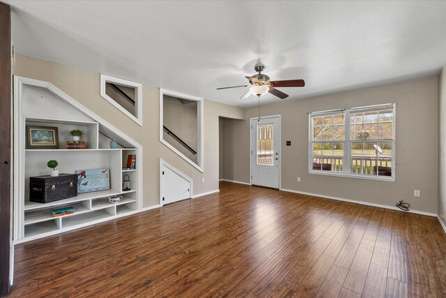 182 Kim St, Mount Vernon, TX 75457 - unfurnished living room featuring a ceiling fan, baseboards, built in features, and wood finished floors