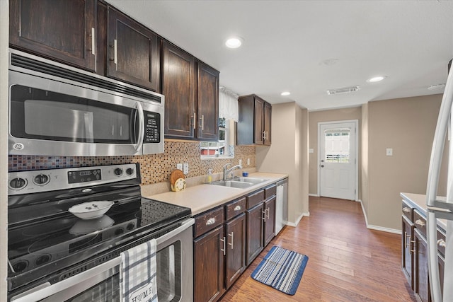182 Kim St, Mount Vernon, TX 75457 - kitchen featuring dark brown cabinetry, light wood-style floors, stainless steel appliances, tasteful backsplash, and visible vents