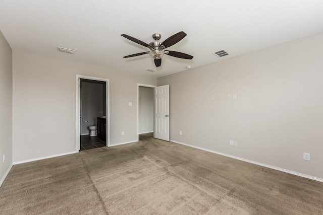 unfurnished bedroom featuring visible vents, ensuite bathroom, baseboards, and carpet floors