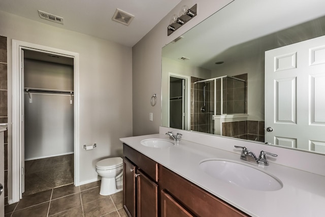 bathroom featuring visible vents, a shower stall, toilet, and a sink