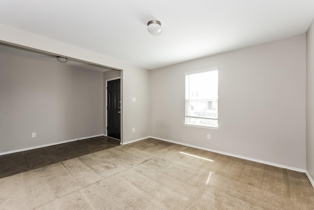 spare room featuring baseboards and carpet