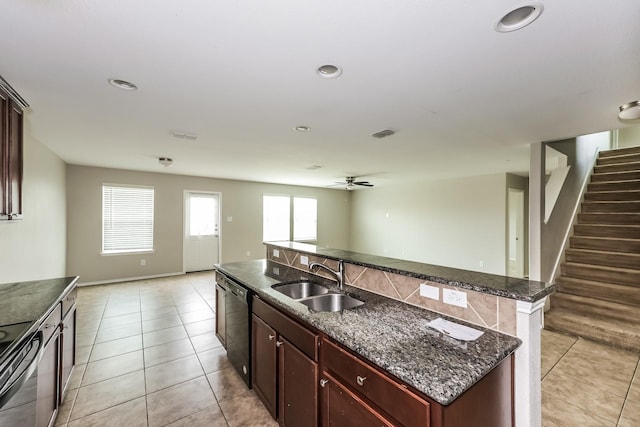 kitchen with a sink, open floor plan, electric range oven, light tile patterned floors, and a kitchen island with sink