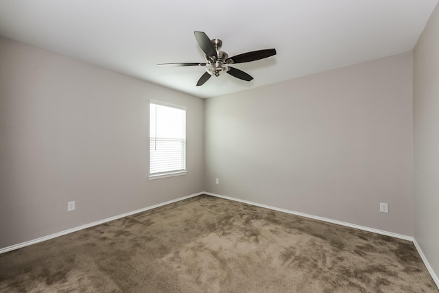 carpeted empty room with baseboards and a ceiling fan