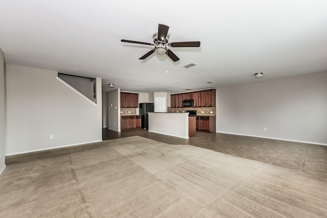unfurnished living room featuring carpet flooring, a ceiling fan, visible vents, and baseboards
