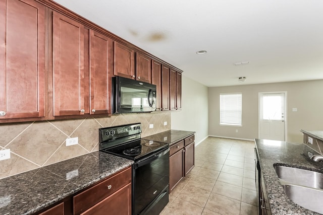 kitchen with tasteful backsplash, baseboards, light tile patterned floors, black appliances, and a sink