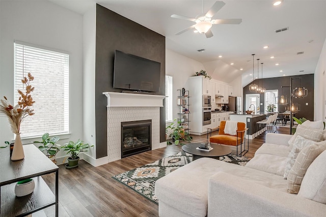 2320 Stella Ln, Northlake, TX 76247 - living room featuring a ceiling fan, light wood-style flooring, a fireplace, vaulted ceiling, and baseboards