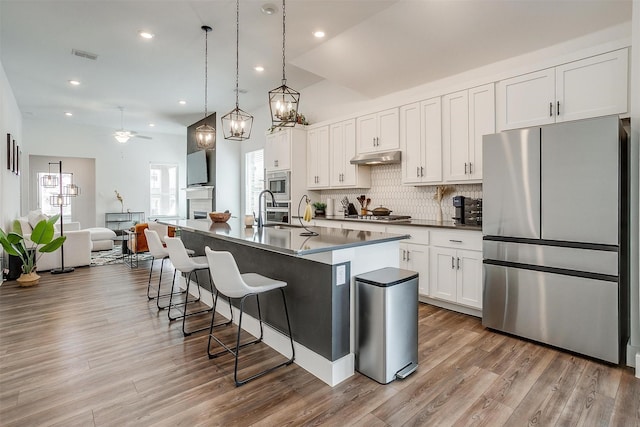 2320 Stella Ln, Northlake, TX 76247 - kitchen with stainless steel appliances, a kitchen breakfast bar, ceiling fan, backsplash, and a center island with sink