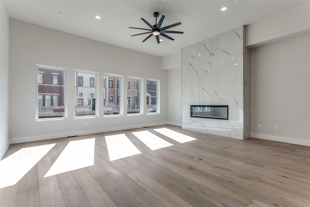 235 E Nash St Unit 113, Grapevine, TX 76051 - unfurnished living room featuring wood finished floors, recessed lighting, baseboards, ceiling fan, and a high end fireplace