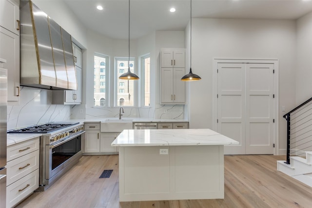 235 E Nash St Unit 113, Grapevine, TX 76051 - kitchen with double oven range, a sink, ventilation hood, backsplash, and light wood-type flooring