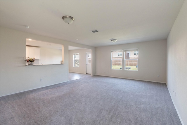 carpeted empty room featuring visible vents and baseboards