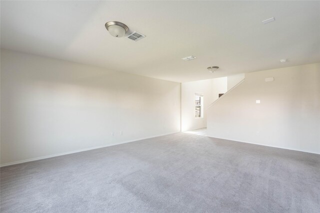 spare room featuring visible vents, carpet flooring, and baseboards