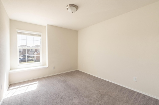 unfurnished room with carpet and baseboards
