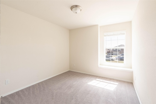 carpeted empty room featuring baseboards