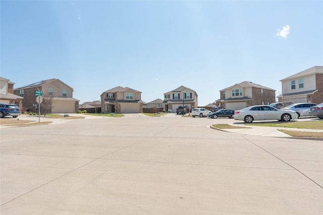 view of street with sidewalks, a residential view, curbs, and traffic signs