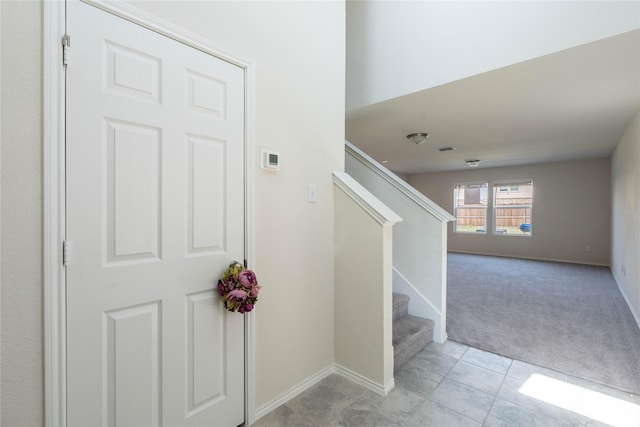 stairs featuring tile patterned flooring, carpet, and baseboards