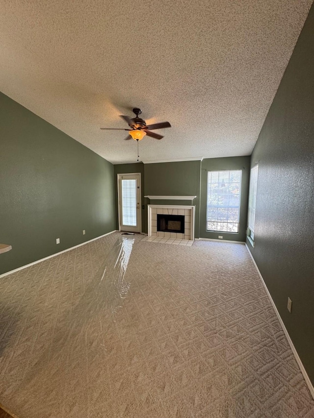 8208 Cloverglen Ln, Fort Worth, TX 76123 - unfurnished living room featuring a tiled fireplace, a wealth of natural light, carpet floors, and ceiling fan