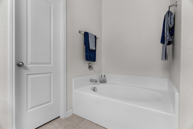 bathroom featuring tile patterned floors and a bath