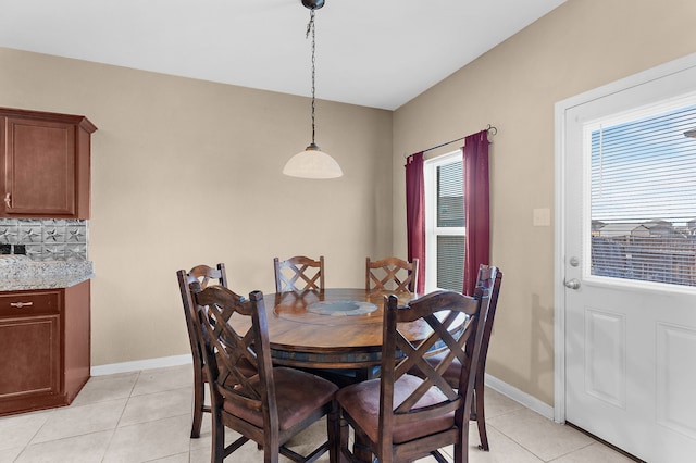 dining space with baseboards and light tile patterned flooring
