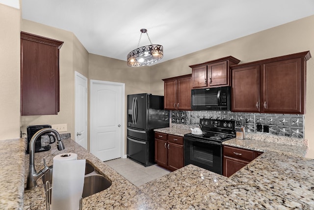 kitchen featuring black appliances, a sink, backsplash, light tile patterned floors, and light stone countertops