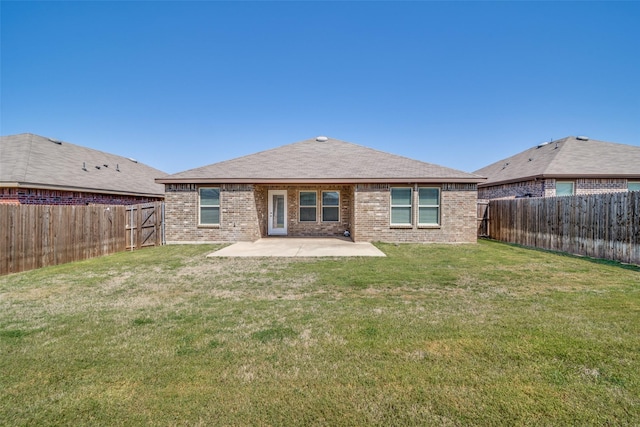 back of property featuring a patio area, a fenced backyard, brick siding, and a lawn