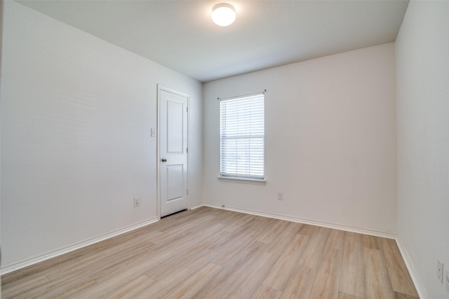 empty room with light wood-style flooring and baseboards