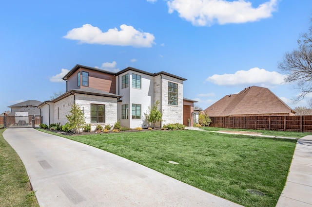 view of front of home featuring a gate, stone siding, and driveway