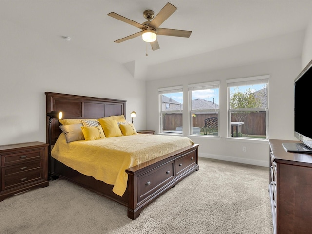 bedroom featuring light colored carpet, lofted ceiling, baseboards, and ceiling fan