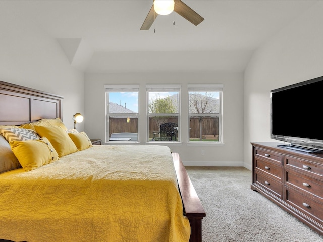 bedroom featuring light colored carpet, lofted ceiling, baseboards, and multiple windows