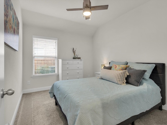 carpeted bedroom featuring lofted ceiling, baseboards, and a ceiling fan