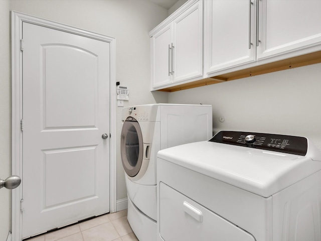 laundry room featuring cabinet space, separate washer and dryer, and light tile patterned flooring