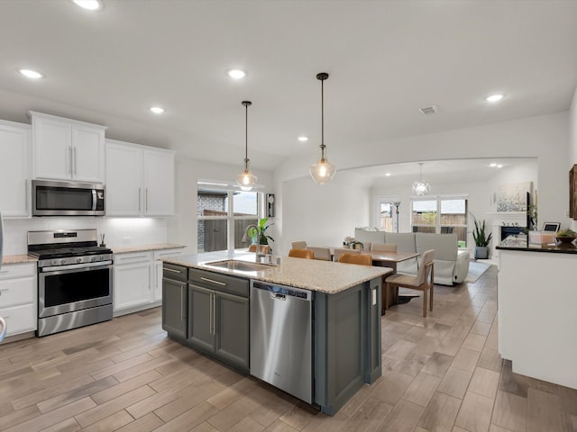 kitchen with a sink, recessed lighting, white cabinetry, and appliances with stainless steel finishes