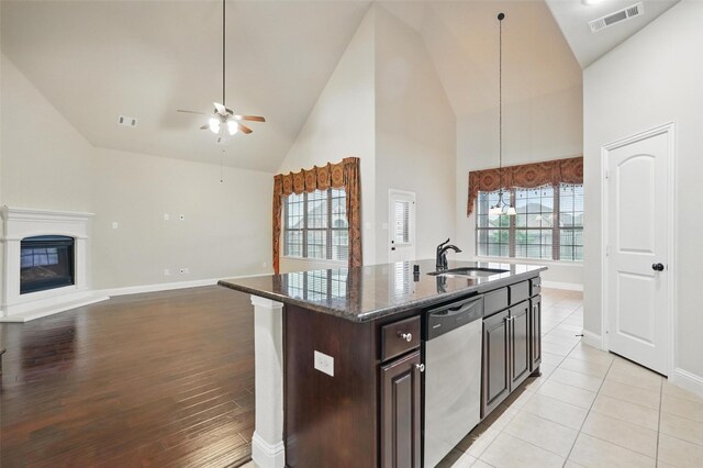 kitchen with a sink, stainless steel dishwasher, open floor plan, and visible vents