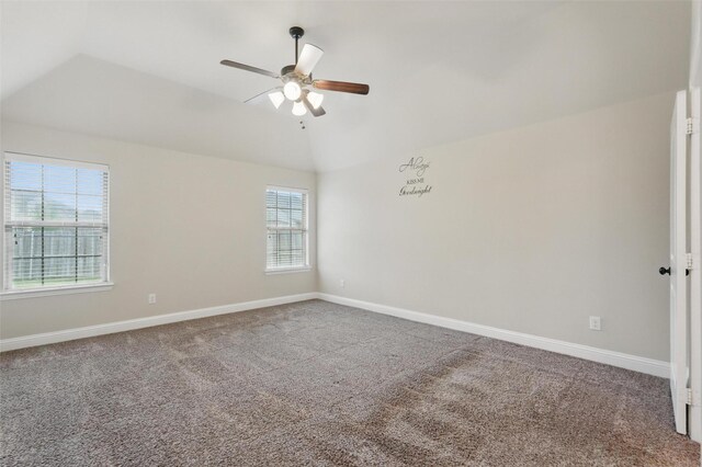 carpeted empty room featuring a ceiling fan, baseboards, and vaulted ceiling