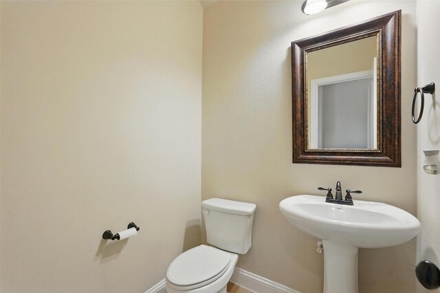 bathroom with baseboards and toilet
