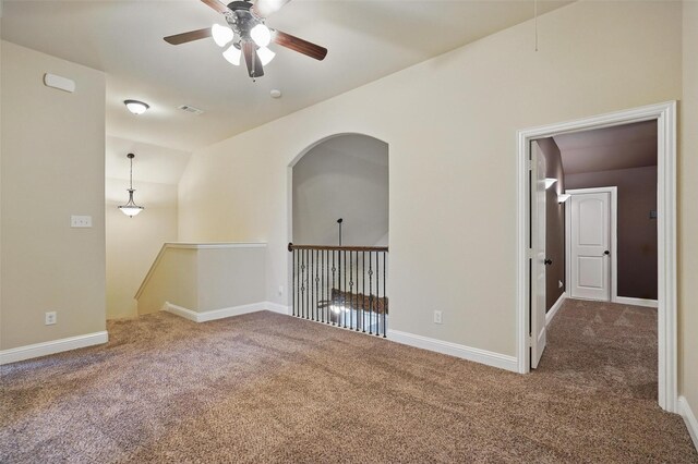 empty room featuring carpet floors, ceiling fan, baseboards, and lofted ceiling