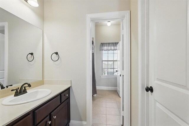 bathroom featuring baseboards, tile patterned flooring, and vanity