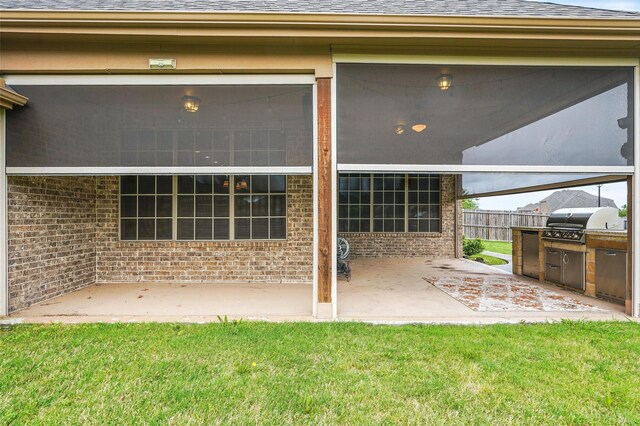 rear view of property with a lawn, a shingled roof, a patio area, and brick siding