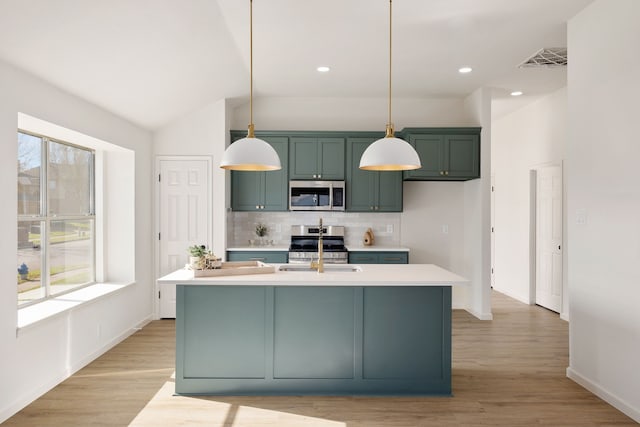 kitchen with stainless steel appliances, green cabinetry, light countertops, and decorative backsplash