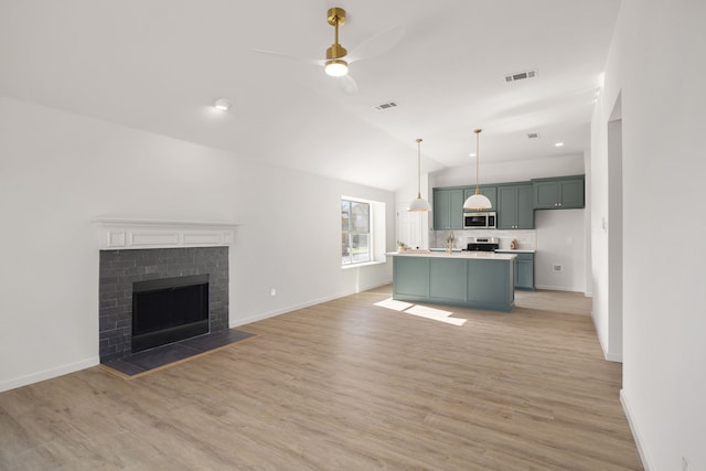unfurnished living room with a ceiling fan, vaulted ceiling, visible vents, light wood finished floors, and baseboards