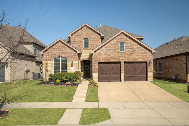 view of front of home with cooling unit, driveway, brick siding, a front yard, and a garage