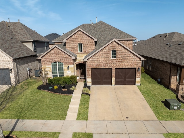 traditional-style house with a front lawn, roof with shingles, driveway, brick siding, and a garage