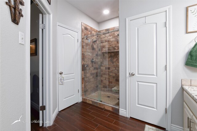 1426 Lakeview Rd, Abilene, TX 79602 - bathroom with vanity, wood finish floors, baseboards, and a stall shower