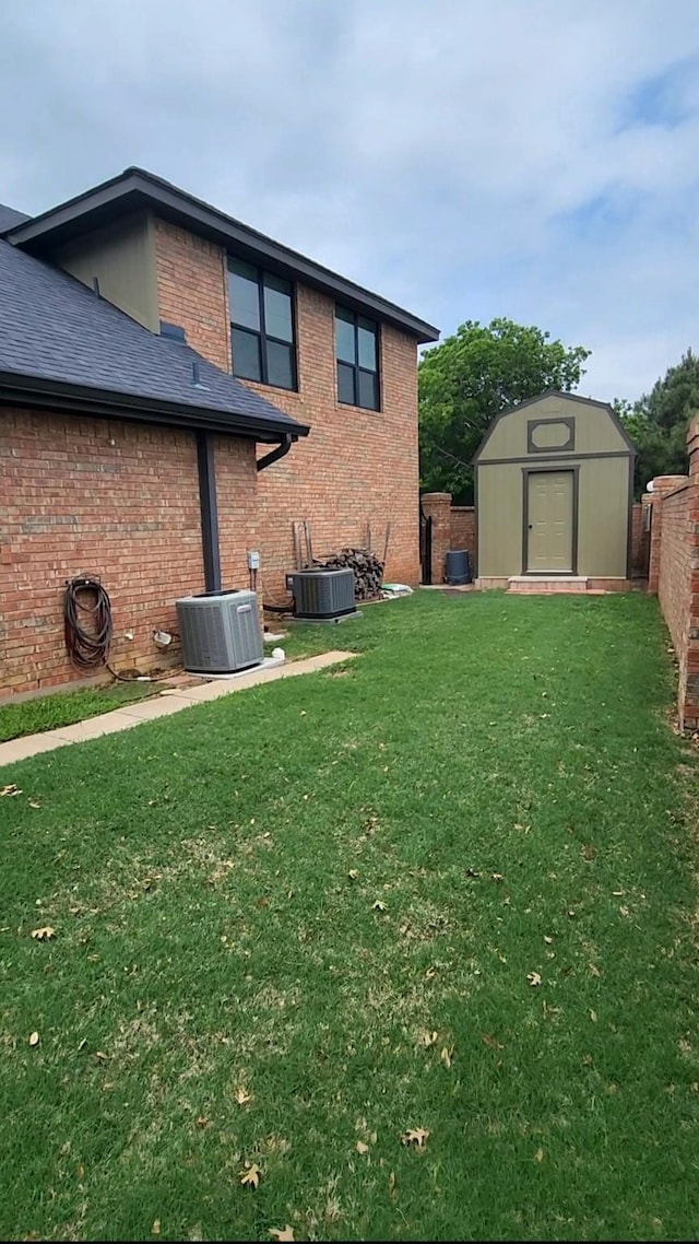 1426 Lakeview Rd, Abilene, TX 79602 - rear view of property featuring an outdoor structure, cooling unit, a storage unit, brick siding, and a yard