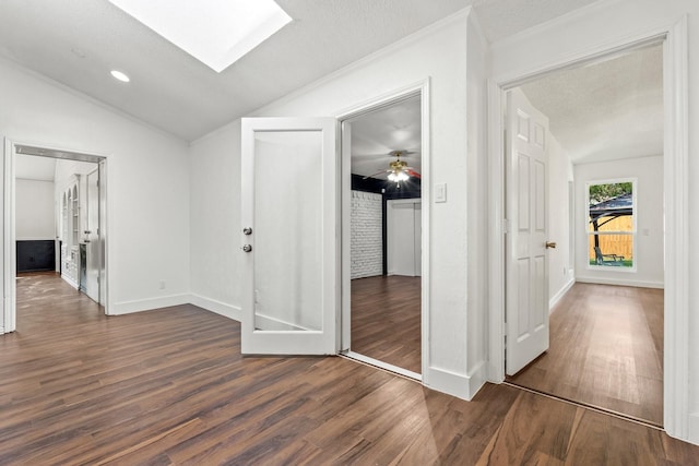3005 Club Hill Dr, Garland, TX 75043 - hallway featuring vaulted ceiling with skylight, dark wood-style floors, and baseboards
