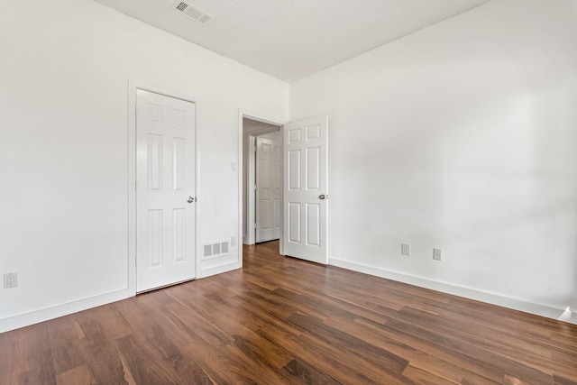 3005 Club Hill Dr, Garland, TX 75043 - unfurnished bedroom featuring dark wood-style floors, visible vents, and baseboards